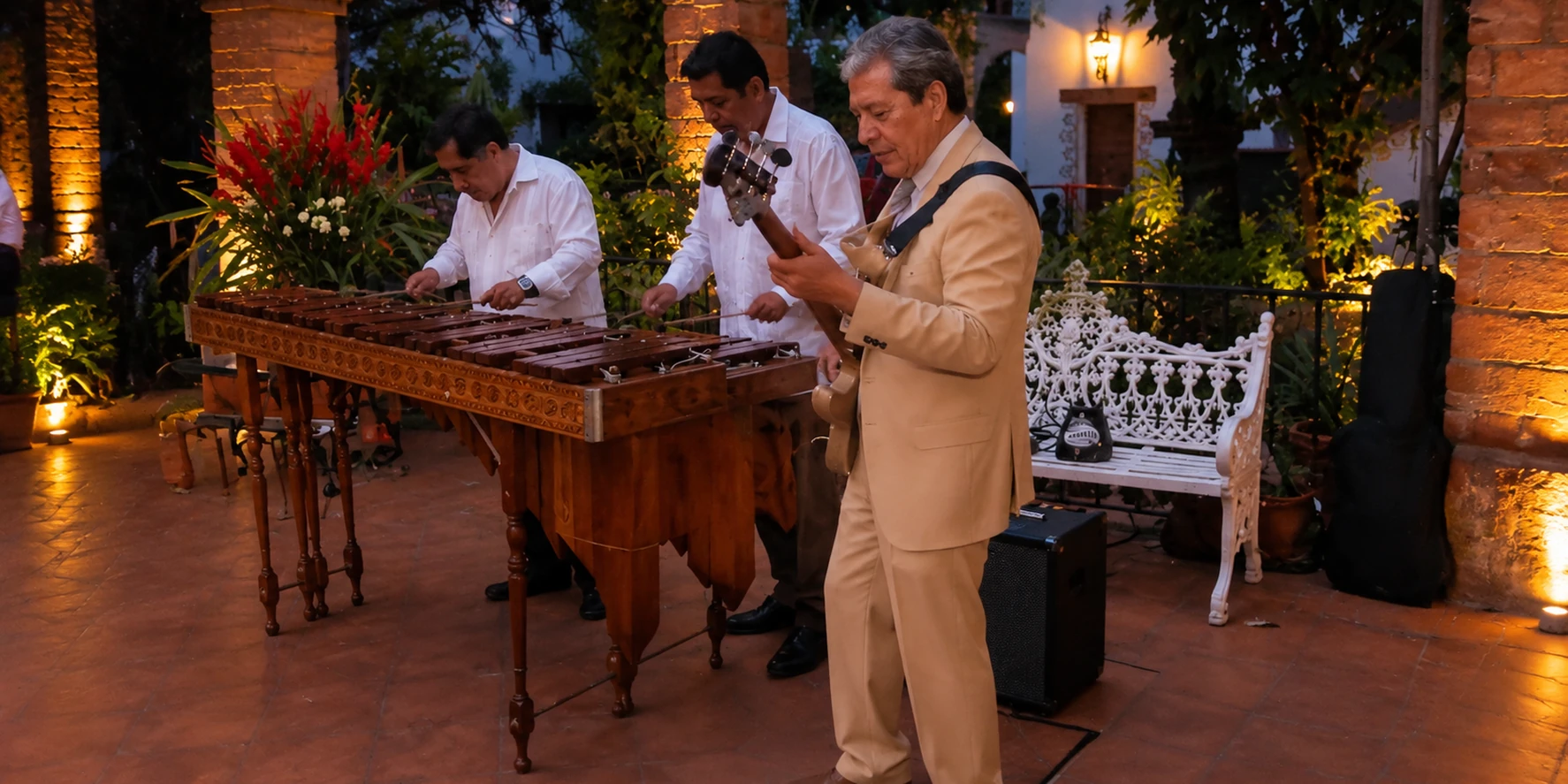 Músicos interpretando la marimba en un patio iluminado